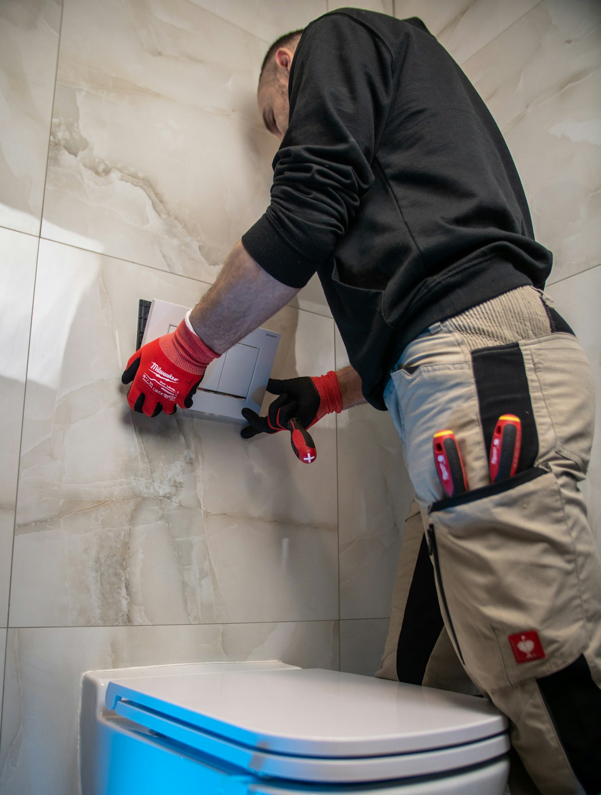 Plumber installing a fixture with protective gloves on